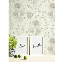 Scene met bloemenbehang, twee ingelijste posters met de tekst liefde en adem, potplant en limoenen