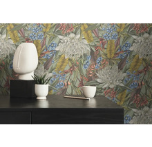 Decoratief interieur met bloemenbehang, gezichtssculptuur en plant in pot op een donkere tafel.