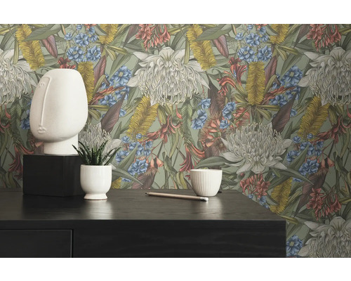 Decoratief interieur met bloemenbehang, gezichtssculptuur en plant in pot op een donkere tafel.