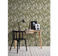 Interieurvoorbeeld met een bureau, een lamp en een patroonbehang met plantmotieven.