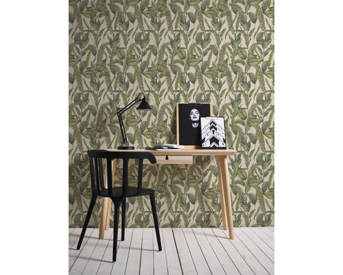 Interieurvoorbeeld met een bureau, een lamp en een patroonbehang met plantmotieven.