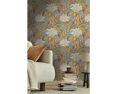 Woonkamer met vliesbehang met bloemmotief, bank en stapel boeken.