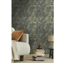 Kamer met jungle behang, bank, kussen, lamp en stapel boeken.