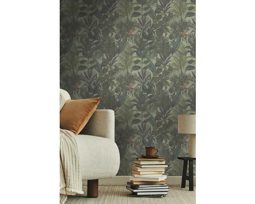 Kamer met jungle behang, bank, kussen, lamp en stapel boeken.