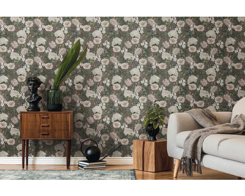 Woonkamer met bloemenbehang, bank en houten meubels