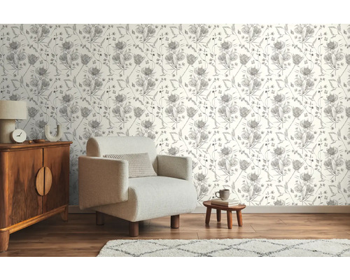 Woonkamer met patroonbehang, fauteuil en houten dressoir