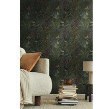 Woonkamer met junglebehang, bank, tafellamp en stapel boeken