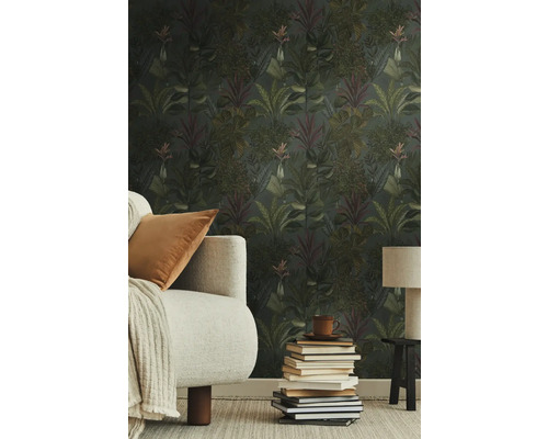 Woonkamer met junglebehang, bank, tafellamp en stapel boeken