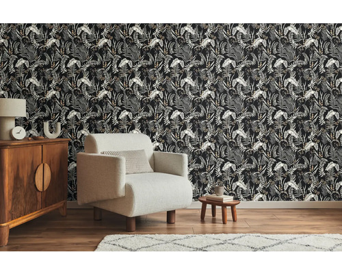 Woonkamer met behang met jungleprint, fauteuil, dressoir en tapijt