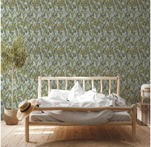 Slaapkamer met bed voor een botanisch behang met bladeren
