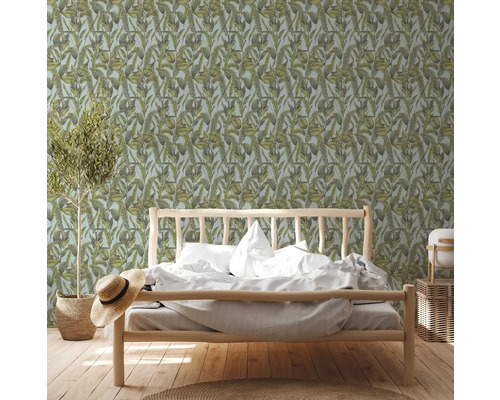 Slaapkamer met bed voor een botanisch behang met bladeren