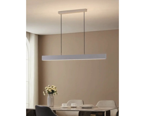 Rechthoekige hanglamp van metaal boven een eettafel.