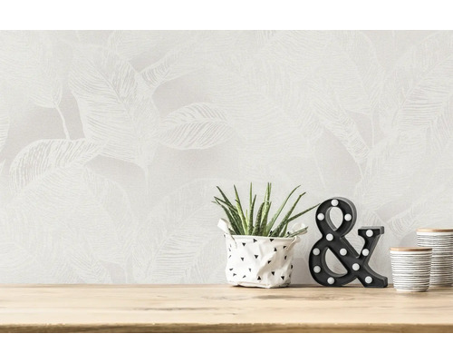 Decoratieve scène met behang met bladmotief, kamerplant, lichtsymbool en bekers op een houten tafel