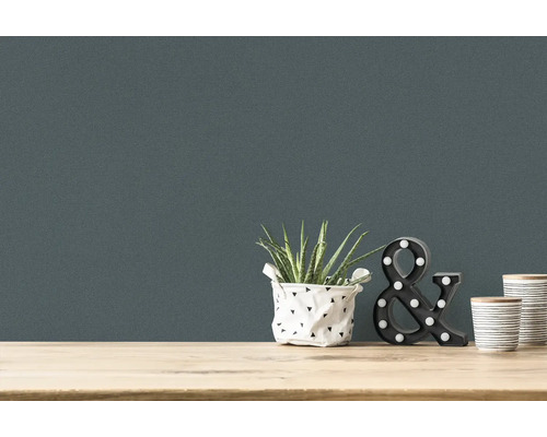 Close-up van een wandbehang met kamerplant, decoratieve ampersand en twee bekers op een tafel