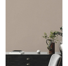 Decoratieve commode met boeken, kunstvoorwerp en plant in een lichte kamer.