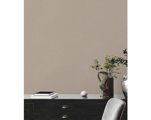 Decoratieve commode met boeken, kunstvoorwerp en plant in een lichte kamer.