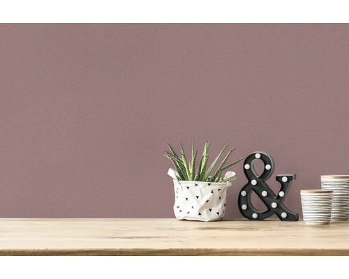 Close-up van een muur met textielbehang en decoratie op een tafel