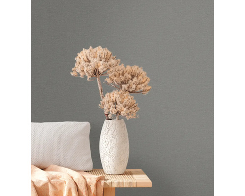 Close-up van grijs vliesbehang met bloemstuk op een bijzettafel