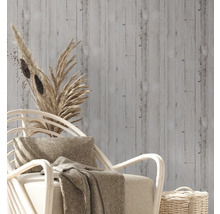 Decoratief behang met houten design in een interieur met een fauteuil en decoratie.