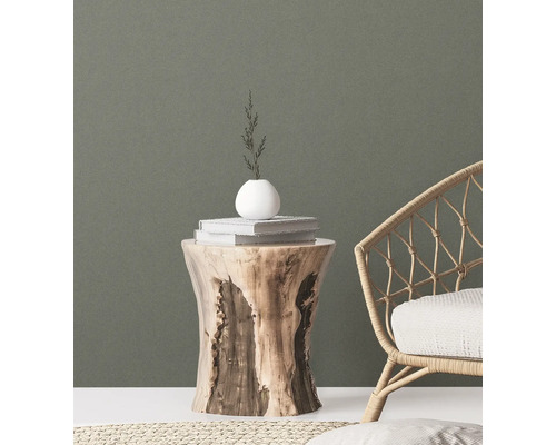 Decoratieve scène met een houten kruk, boeken, een vaas en een rotan stoel voor een stijlvolle ambiance.