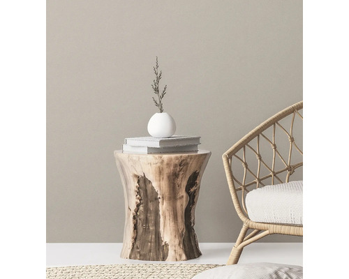 Decoratieve scène met houten kruk, boeken, vaas en rotan stoel