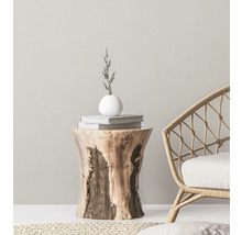 Decoratief interieur met een houten bijzettafel, boeken, een vaas en een rotan stoel.