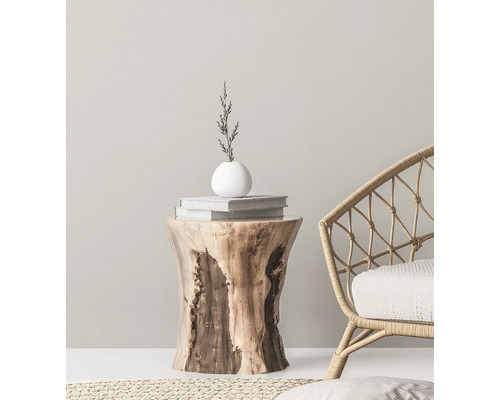 Decoratief interieur met een houten bijzettafel, boeken, een vaas en een rotan stoel.
