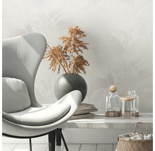 Scene met fauteuil, droogbloemen in vaas, boeken en decoratieve glazen