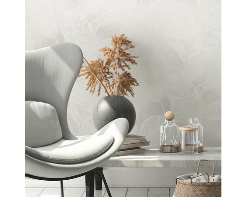 Scene met fauteuil, droogbloemen in vaas, boeken en decoratieve glazen