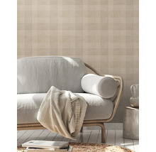 Woonkamer met patroonbehang, bank en decoratieve elementen voor een huiselijke sfeer.