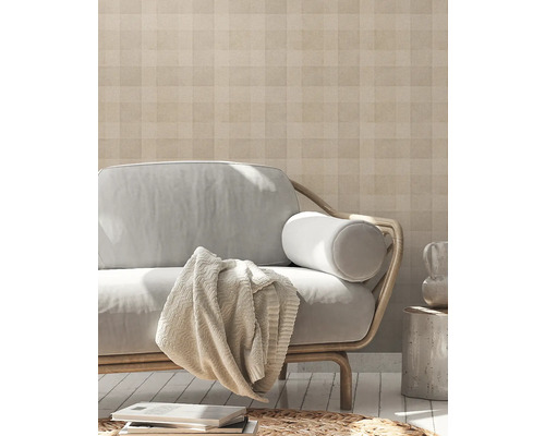 Woonkamer met patroonbehang, bank en decoratieve elementen voor een huiselijke sfeer.