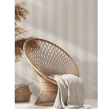 Scene met rotan stoel, deken, mand en gestreept behang voor interieurontwerp