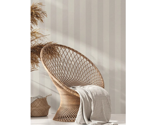 Scene met rotan stoel, deken, mand en gestreept behang voor interieurontwerp