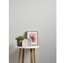 Decoratief dienblad met kamerplant, decoratieve huizen en ingelijste foto op een ronde bijzettafel