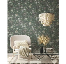 Woonkamer met bloemenbehang, fauteuil, salontafel en hanglamp