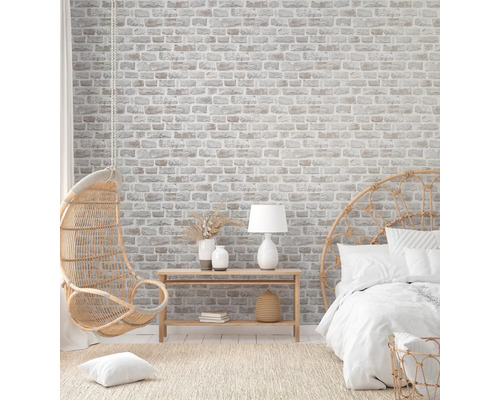 Lichte slaapkamer met bakstenen behang, hangstoel en rotan bed