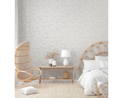 Lichte slaapkamer met rotan meubels en bakstenen muur