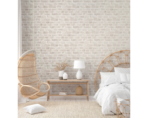 Lichte slaapkamer met bakstenen behang, rotan stoel en bed