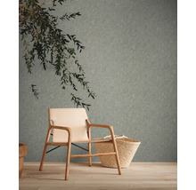 Woonkamer met gemusterd behang, fauteuil en mand