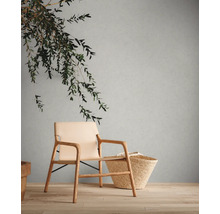 Scene met fauteuil, mand en decoratie op houten vloer voor een muur