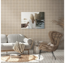 Woonkamer met bank, fauteuil en een muurschildering met een strandthema