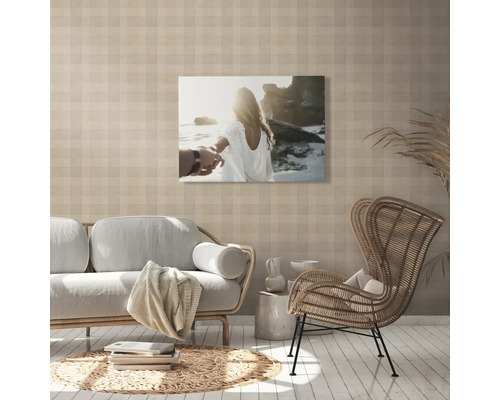 Woonkamer met bank, fauteuil en een muurschildering met een strandthema