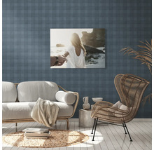 Woonkamer met bank, fauteuil en muurschildering