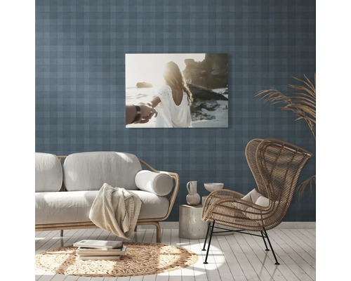 Woonkamer met bank, fauteuil en muurschildering