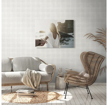 Woonkamer met bank, stoel en muurdecoratie met strandthema