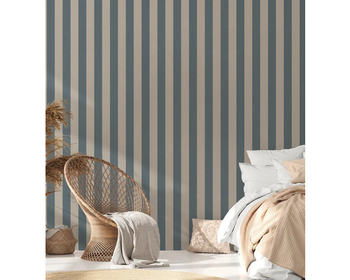 Slaapkamer met gestreept behang, rotan stoel en bed