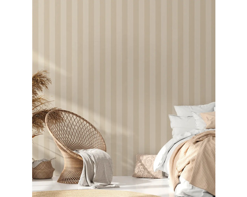 Lichte slaapkamer met gestreept behang, rotan stoel en bed