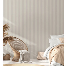 Slaapkamer met gestreept behang, rotan stoel en bed
