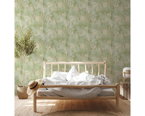 Slaapkamer met bed voor een groen bladerenbehang