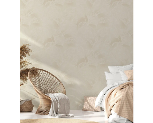 Slaapkamer met rotan stoel, bed en behang met bladmotief